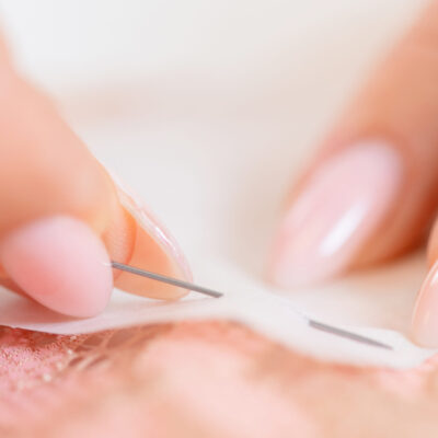 Close up of person pinning cloth together for sewing prep.